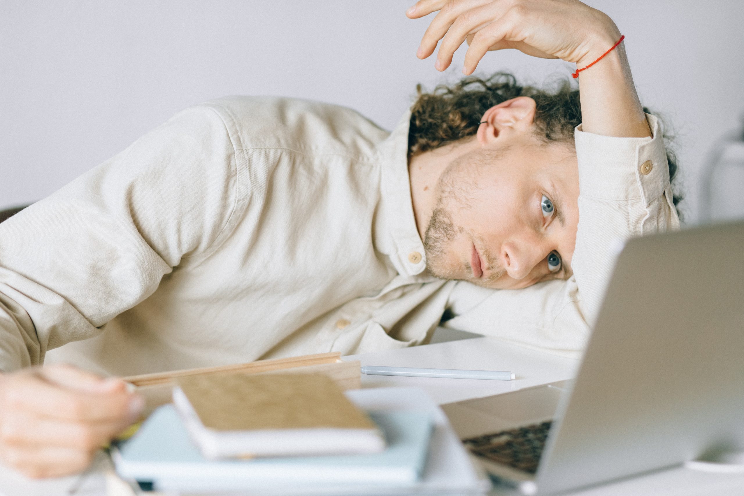 An overwhelmed man staring at his computer while at his desk