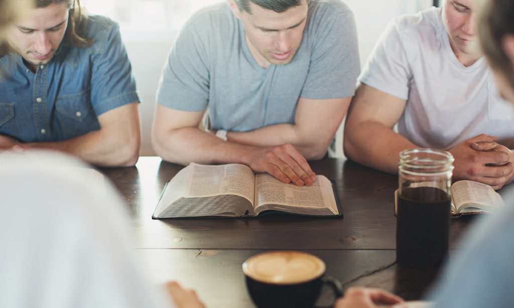 Small group of people reading the Bible and exploring faith-based conflict resolutions